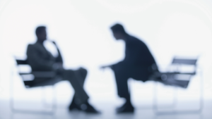 A blurred image of someone in an interview.